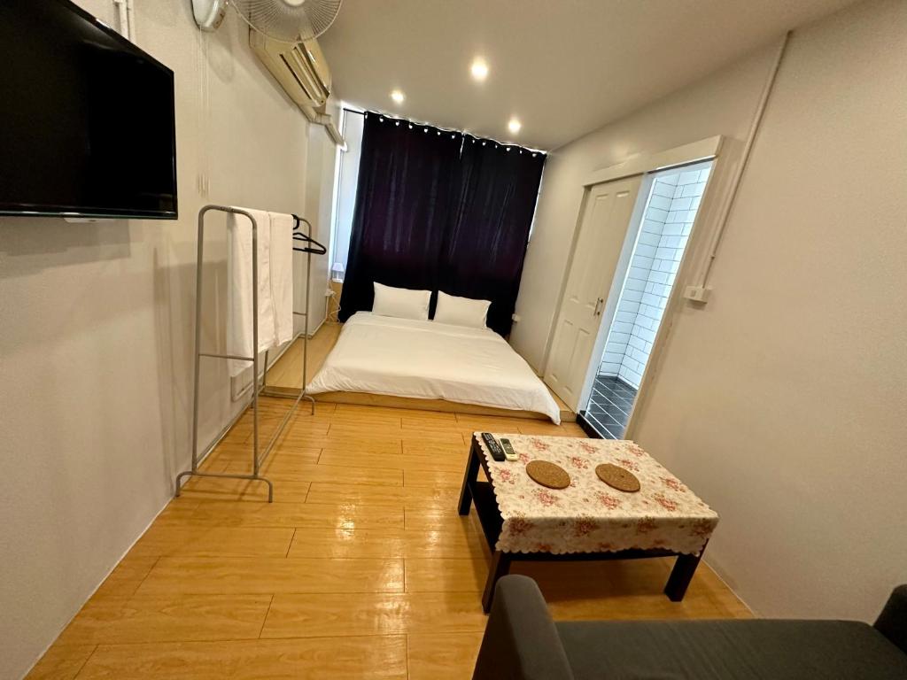 a small room with a bed and a table at The Cute Silom hostel in Bangkok