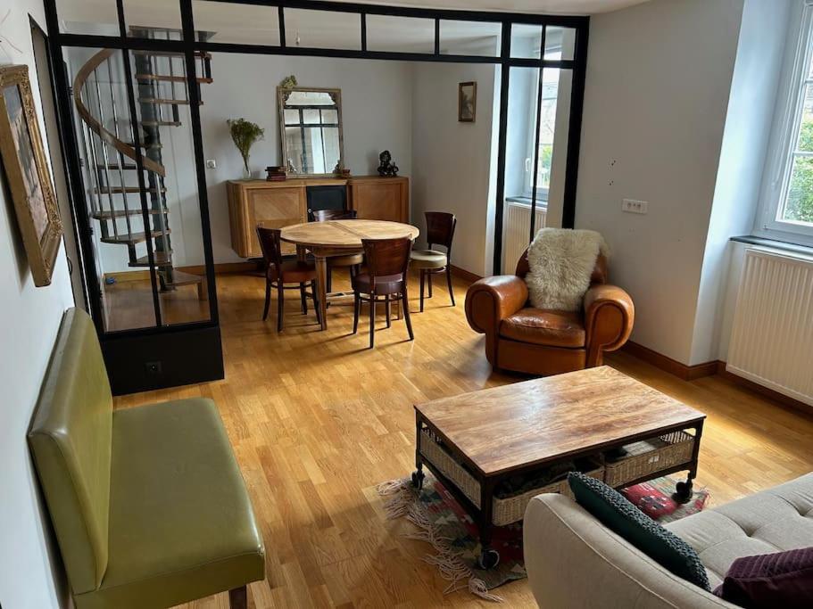 a living room with a couch and a table and chairs at L'Ancrage in Saint Malo