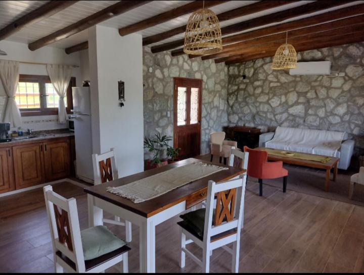 een keuken en woonkamer met een tafel en stoelen bij Cabaña de piedra Los Crespines in San Antonio de Arredondo