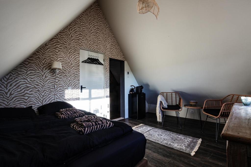 a living room with a black couch and a table at Bed and Relax Terschelling in Midsland