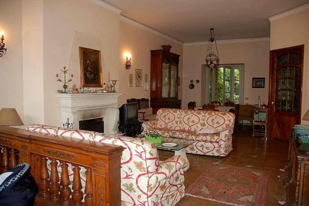 a living room with a couch and a fireplace at Villa Carla, a charming villa in the center of Taormina in Taormina