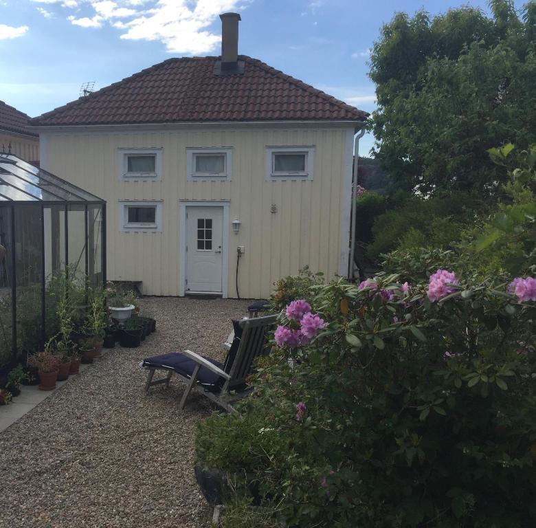 una casa blanca con un banco delante en Lilla Saturnus, en Ljungskile