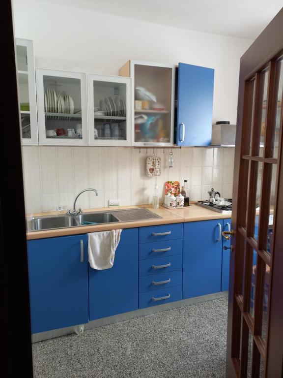 una cocina con armarios azules y fregadero en Casa Vacanza Margherita, en Minucciano