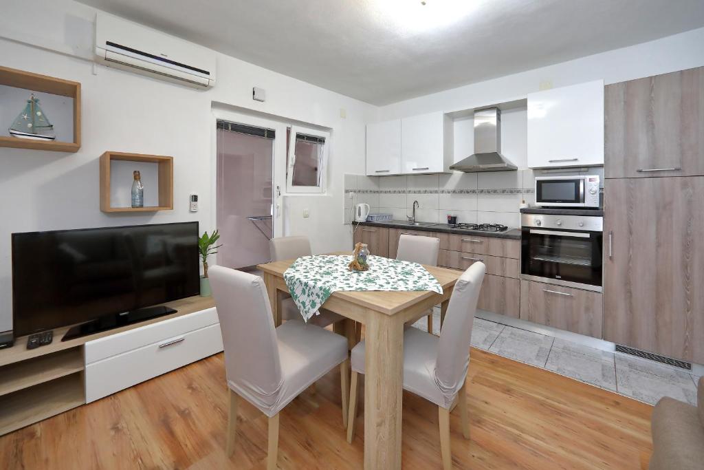 uma cozinha e sala de jantar com mesa e cadeiras em apartment doris em Bibinje