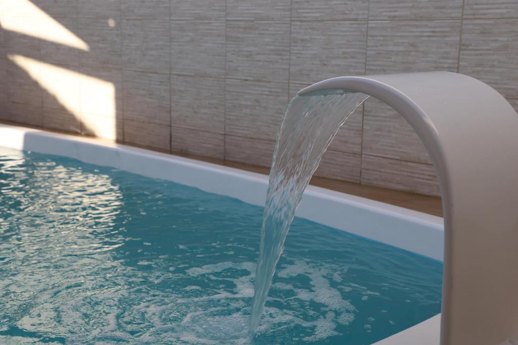 uma fonte de água numa piscina em Casa ampla e agradável com piscina e churrasqueira em Juazeiro