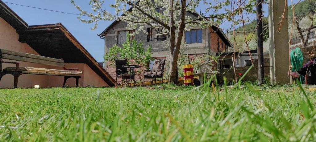 a yard with green grass and a house and a table at Guest House Lejla in Travnik