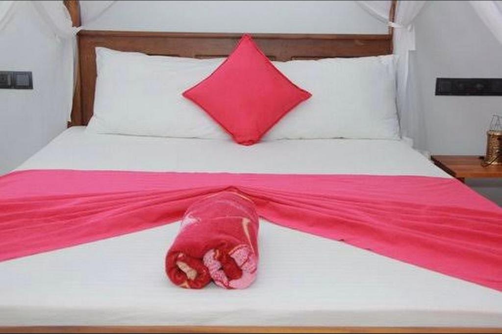ein Bett mit einer rosa Decke drauf in der Unterkunft Sahan Villa in Sri Jayewardenepura Kotte