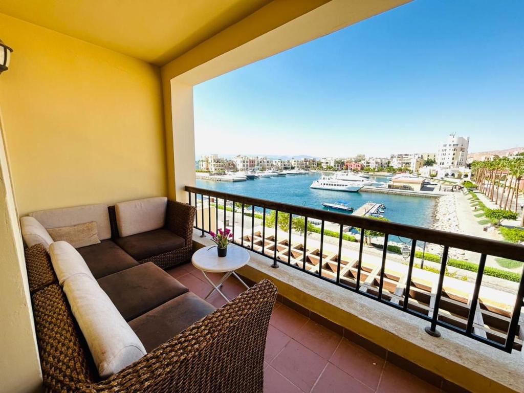 a balcony with a couch and a view of the water at Tala bay aqaba one bedroom nice view in Al Burj