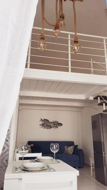 a living room with a blue couch and stairs at La Perla Blu in Calasetta