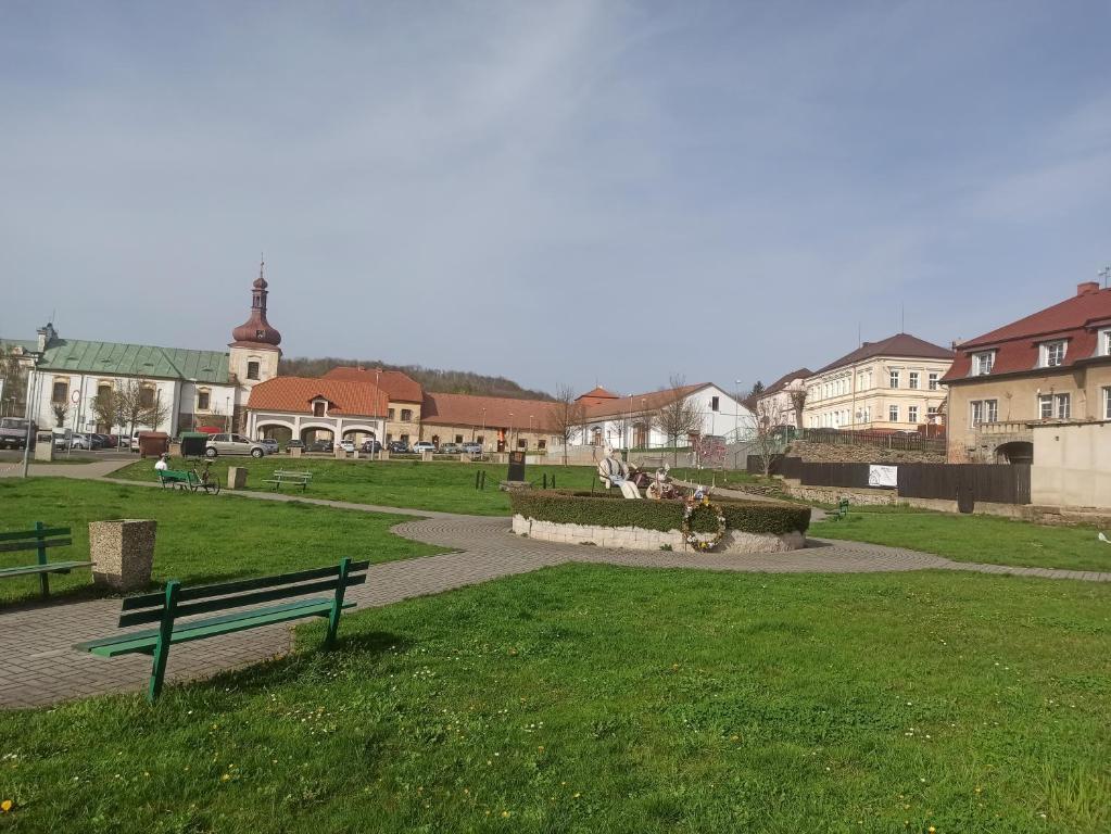 a park with a bench and buildings in the background at Apartmán Kostomlaty pod Milešovkou in Kostomlaty pod Milešovkou