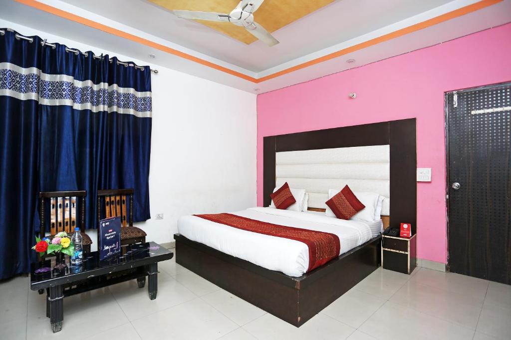 a bedroom with a bed and a pink wall at OYO Hotel Kohinoor in New Delhi