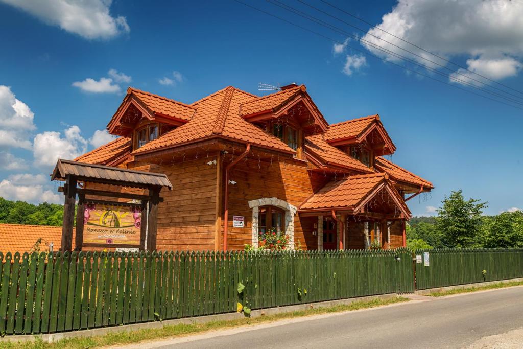una casa de madera con una valla delante en Ranczo w Dolinie - Bałtów, en Bałtów