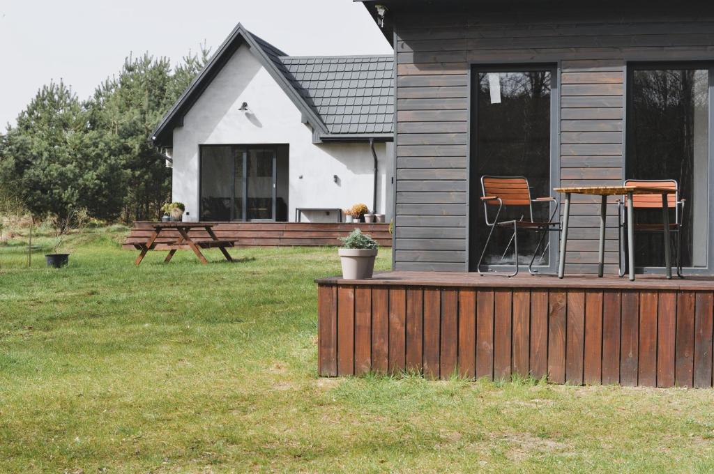een huis met een terras met een picknicktafel en een bank bij Domki na polance in Horyniec