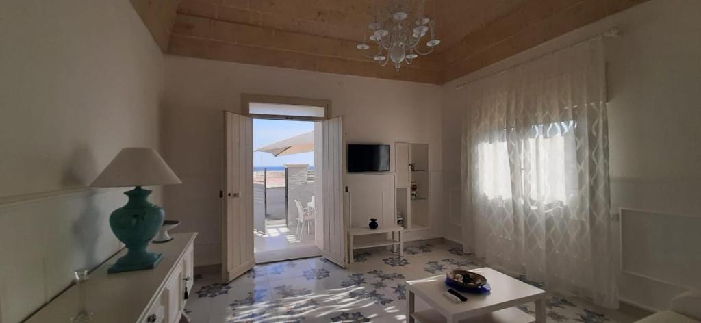 een woonkamer met een kroonluchter en een groot raam bij Il Sole e l'Azzurro in Marina di Lizzano
