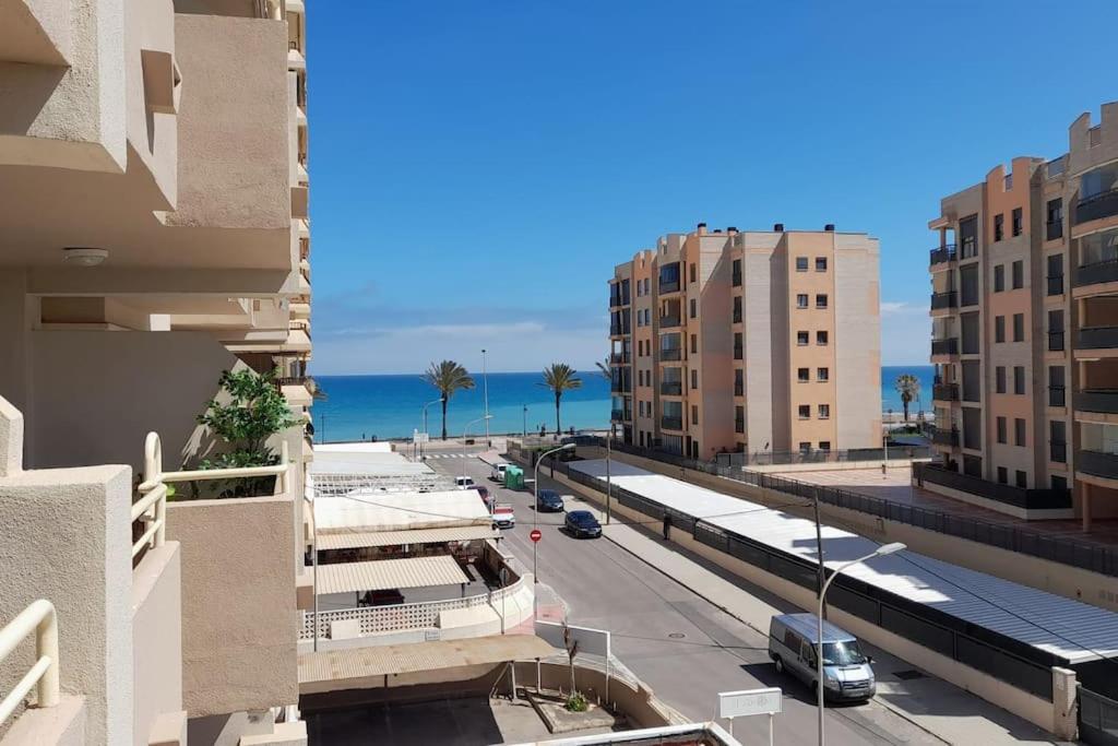 uitzicht op een straat in een stad met gebouwen bij Apartamento muy cerca del mar, piscina, a/a, wifi y garaje. in Benicàssim