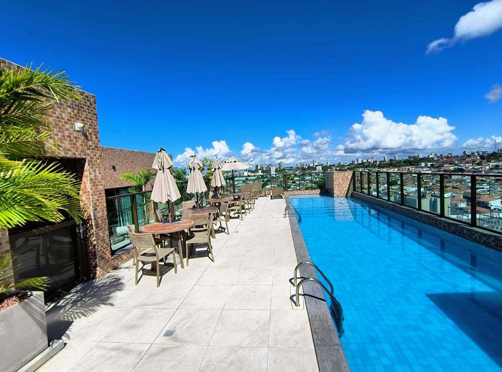 マセイオにあるConforto e tranquilidade, 2 quartos na Pajuçaraの建物内のスイミングプール(テーブル、椅子付)