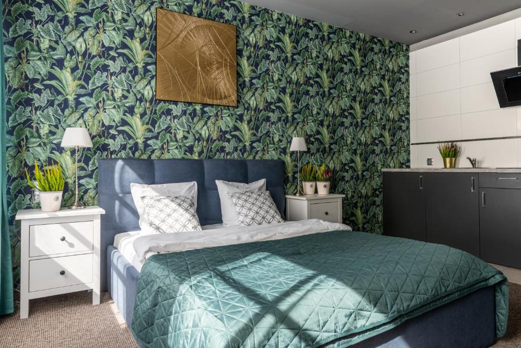 a bedroom with a blue bed and green wallpaper at Staycity Apartments Sukiennice 6 in Wrocław