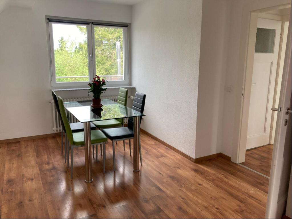 uma sala de jantar com uma mesa com cadeiras e uma janela em Appartment23 em Karlsruhe