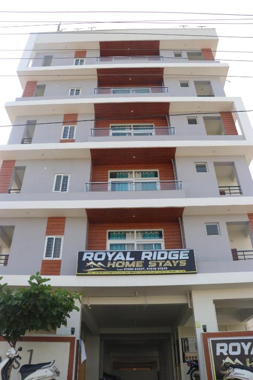 a tall white building with a sign in front of it at ROYAL RIDGE HOME STAYS in Tirupati