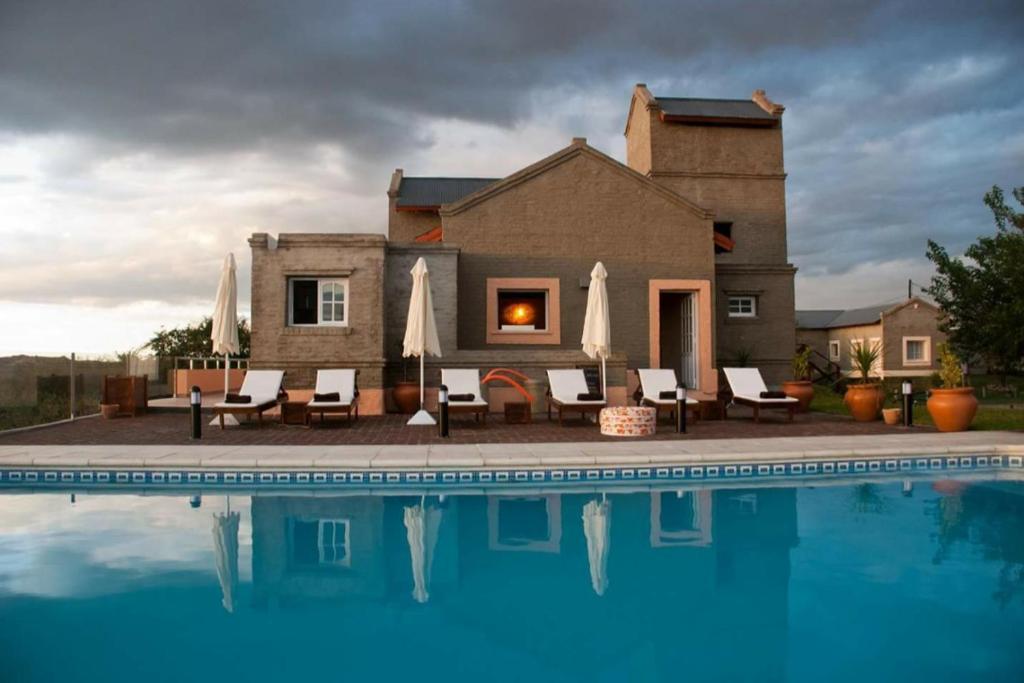 uma casa com piscina em frente a uma casa em DOS AGUAS em Capilla del Monte