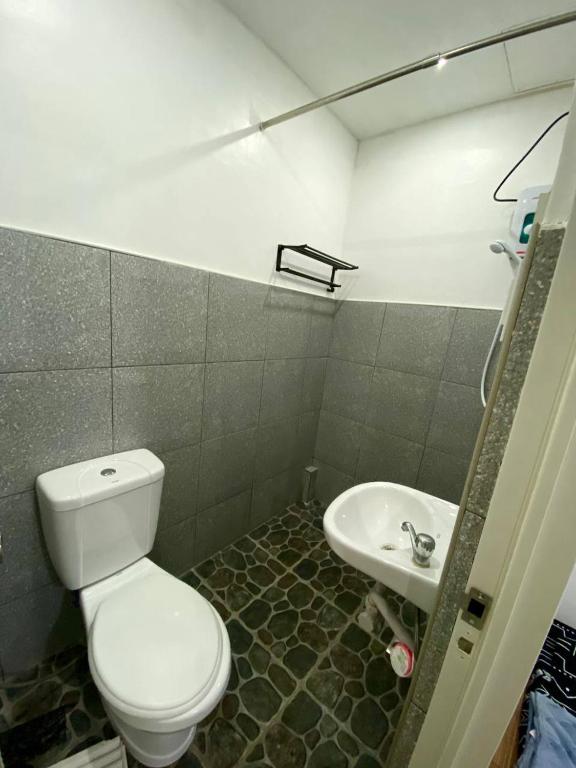 a bathroom with a toilet and a sink at Moalboal Panagsama beach TopBudz Hostel in Moalboal
