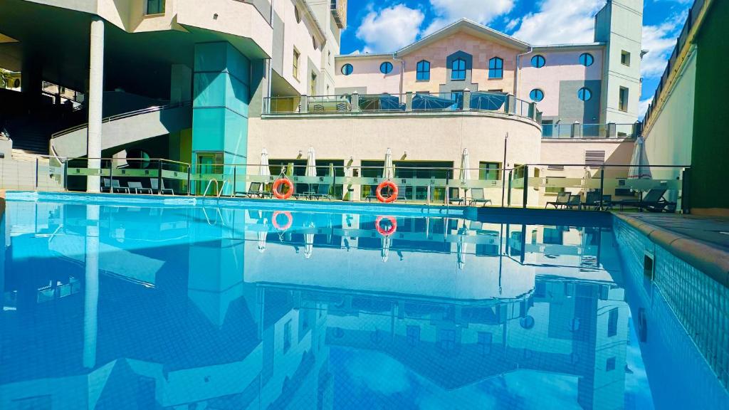 een zwembad voor een gebouw bij Hotel Badajoz Center in Badajoz