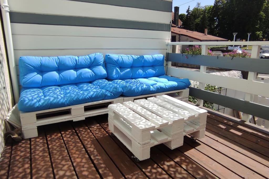 a blue couch sitting on top of a deck at Duplex avec terrasse ombragée in Lempdes