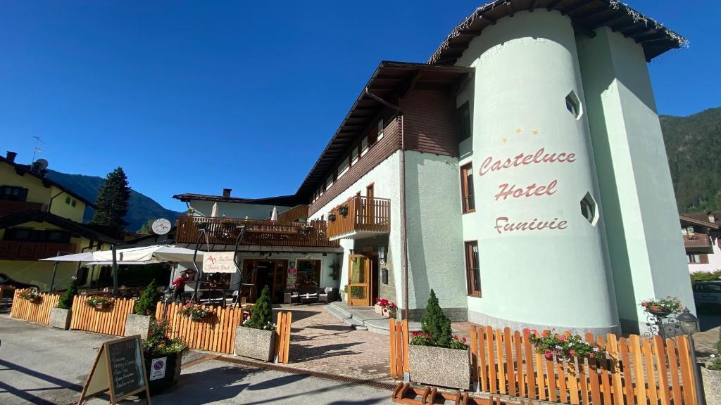 a building with a fence in front of it at Casteluce Hotel Funivie in Pinzolo