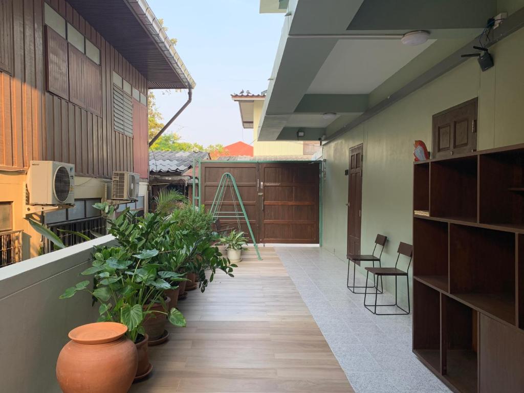 a balcony with plants and chairs on a building at Self check-in apartment by Baiput Hometel in Phra Nakhon Si Ayutthaya