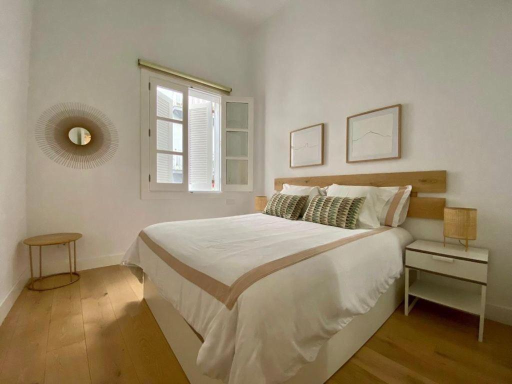 a white bedroom with a large bed and a window at Mia's Apartment in Las Palmas de Gran Canaria