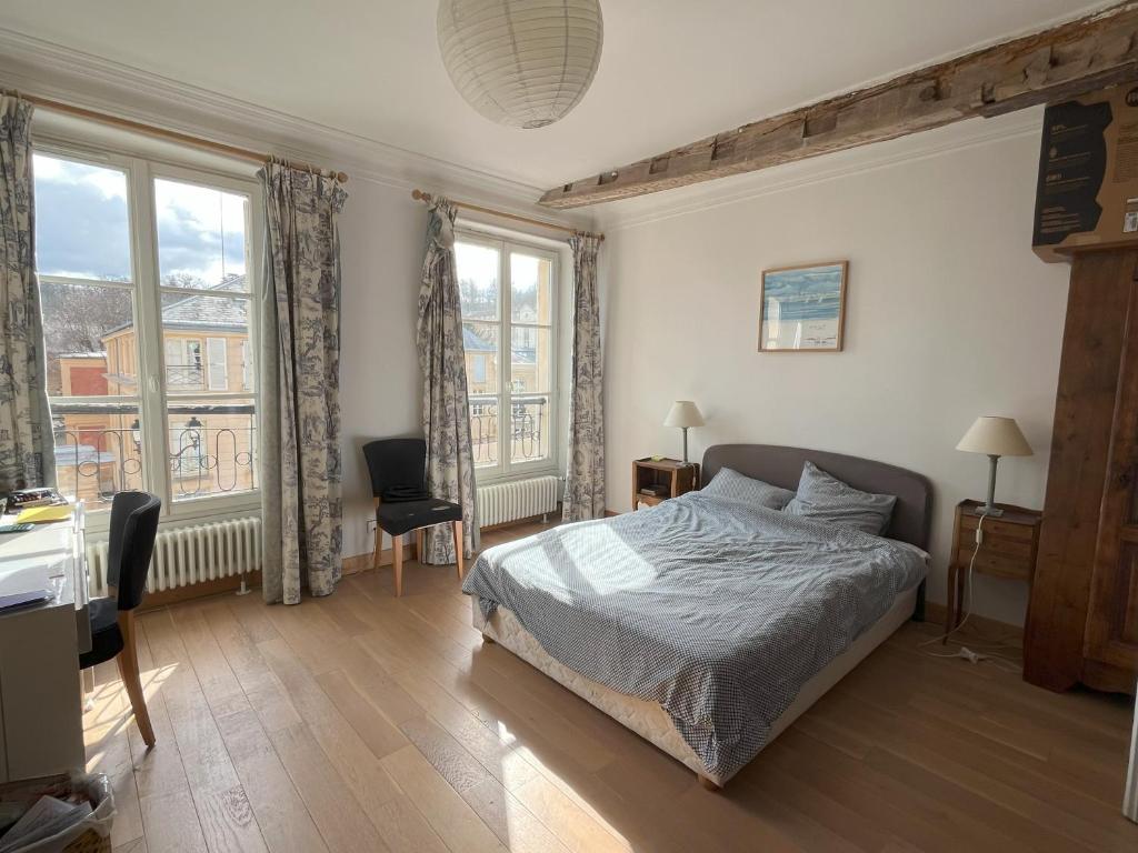 Schlafzimmer mit einem Bett, einem Schreibtisch und Fenstern in der Unterkunft Versailles, quartier Saint Louis in Versailles