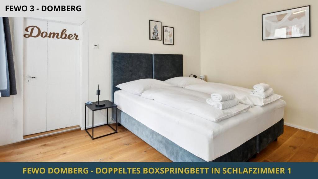 a bedroom with a large bed with white sheets at NEU KapApart15 - 6 schöne FeWos mit Einbauküche, Bad und Balkon in der Altstadt auf Bambergs Insel in Bamberg