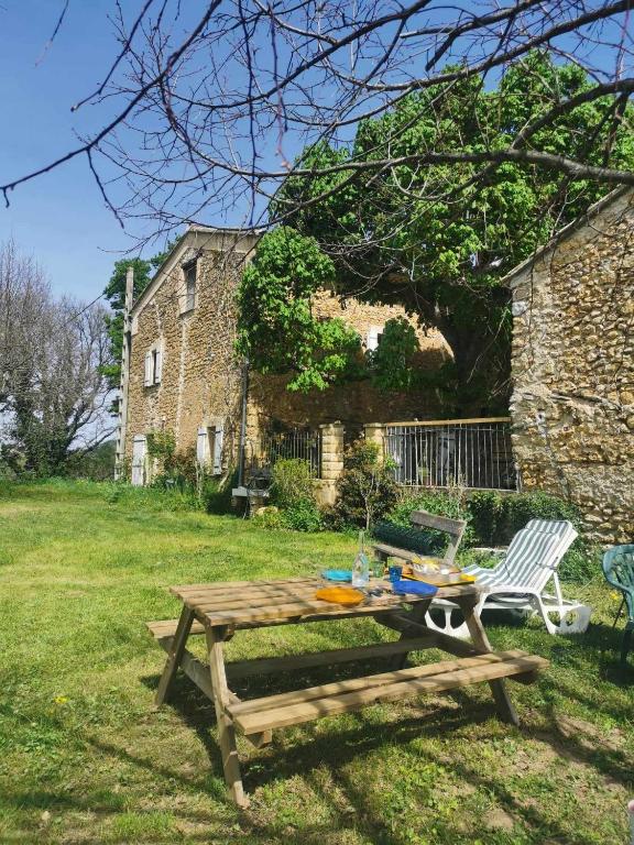une table de pique-nique et une chaise dans une cour dans l'établissement Gîte à la campagne, à Puyméras