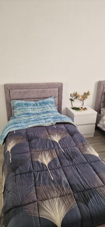 a bedroom with a bed with a blue comforter at Appartamento Mërqi in Lezhë