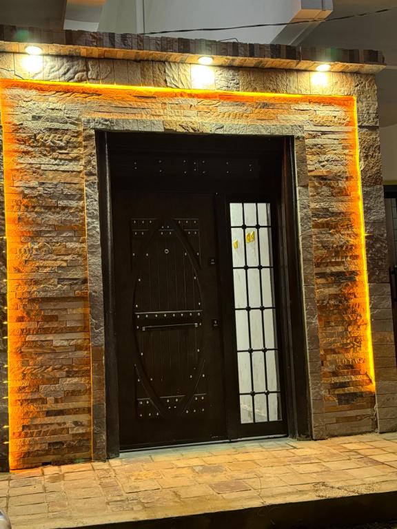 una puerta negra en una pared de ladrillo con luces en Résidence Les Oliviers by Jad Inn en Nuakchot