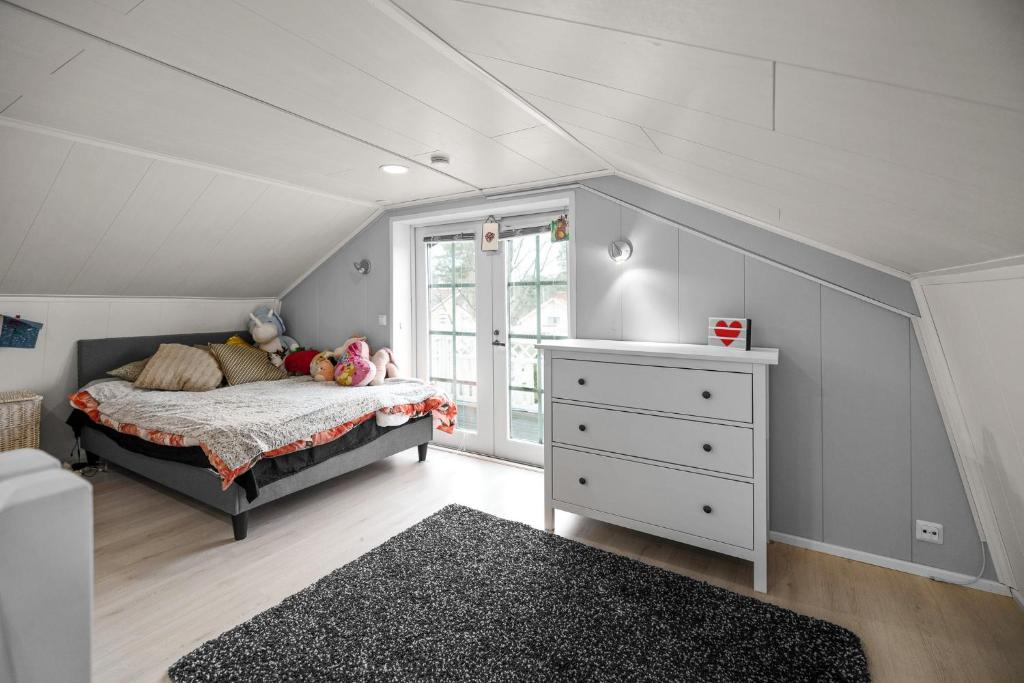 sypialnia z łóżkiem, komodą i oknem w obiekcie Kotoisa talo Keravalla w mieście Kerava