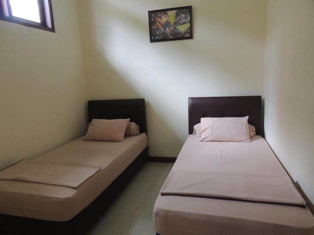 dos camas sentadas una al lado de la otra en una habitación en Villa Tjokro, en Puncak