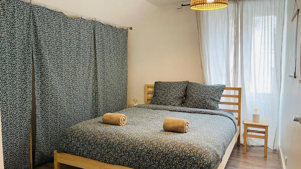 a bedroom with a bed with two pillows on it at Charmante maison a deux pas du centre in Nantes