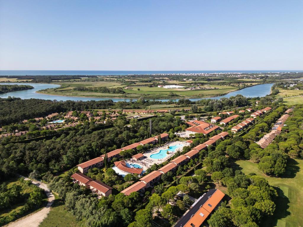 einem Luftblick auf ein Resort mit Pool und Fluss in der Unterkunft Green Village Eco Resort in Lignano Sabbiadoro