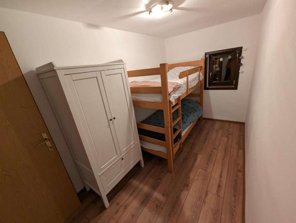 a small room with a bunk bed and a cabinet at Kojadinovica Koliba in Mokra Gora