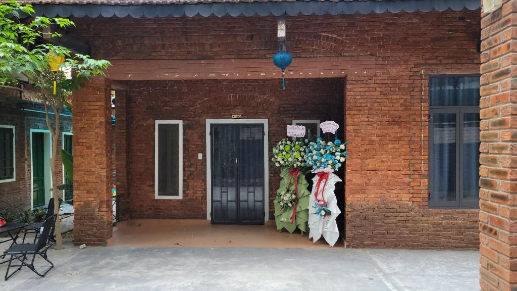 Ein Backsteingebäude mit einer Tür mit einem Haufen Waren in der Unterkunft Oasis Station in Hue