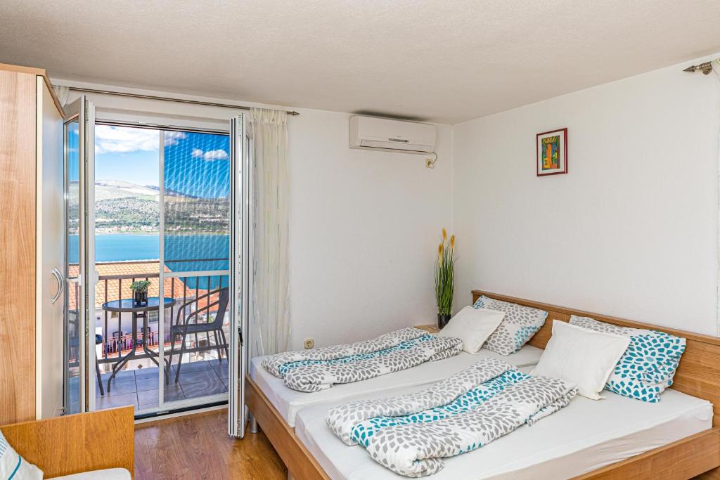2 łóżka w pokoju z balkonem w obiekcie Apartman Simic w Trogirze
