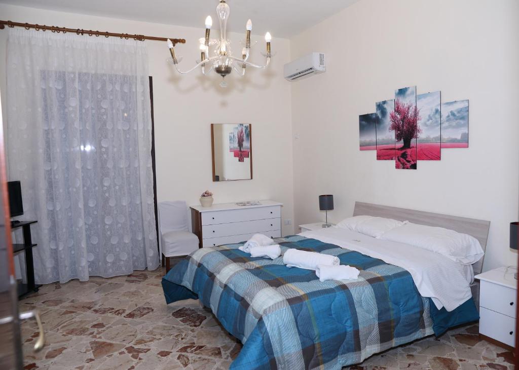 a bedroom with a bed and a chandelier at Casa Mia, vacanze in Marsala