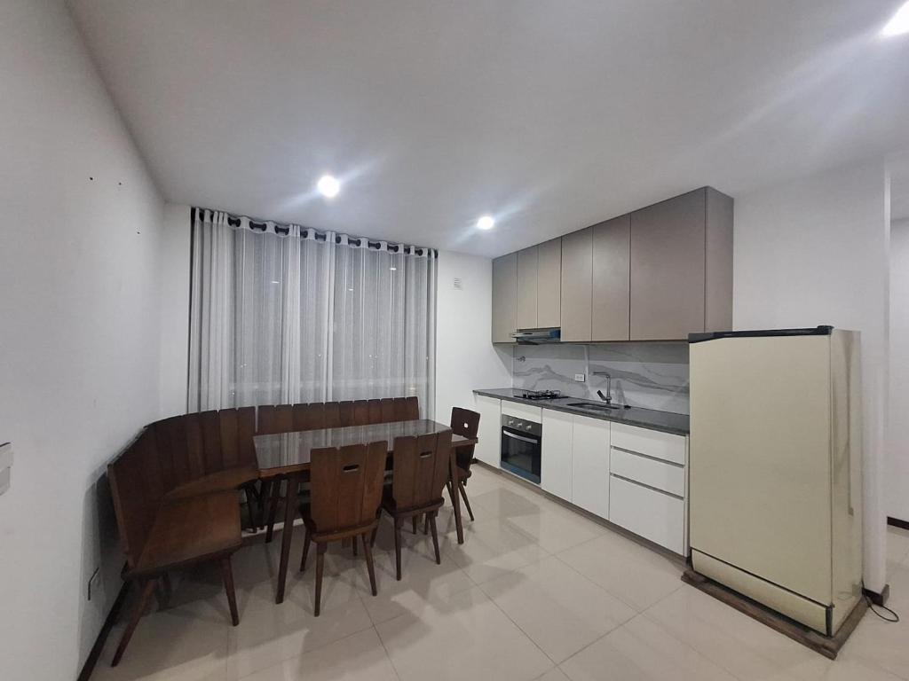 a kitchen with a table and chairs and a refrigerator at Depar land tower in Tarija