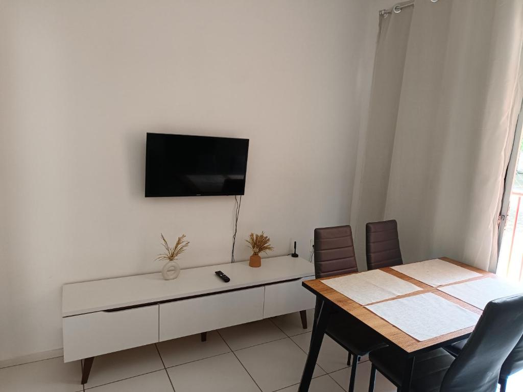 uma sala de estar com uma mesa e uma televisão na parede em Ap 101 Aconchegante e Moderno com 3 quartos, sendo 1 suíte em Teresina