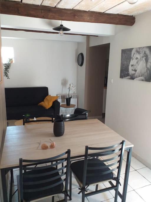 a dining table and chairs in a living room at Maisonette avec jardinet sur le bas du Faron in Toulon