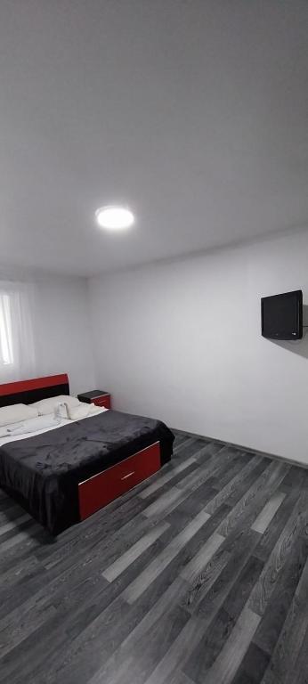 sypialnia z łóżkiem i drewnianą podłogą w obiekcie Home w Piteszti