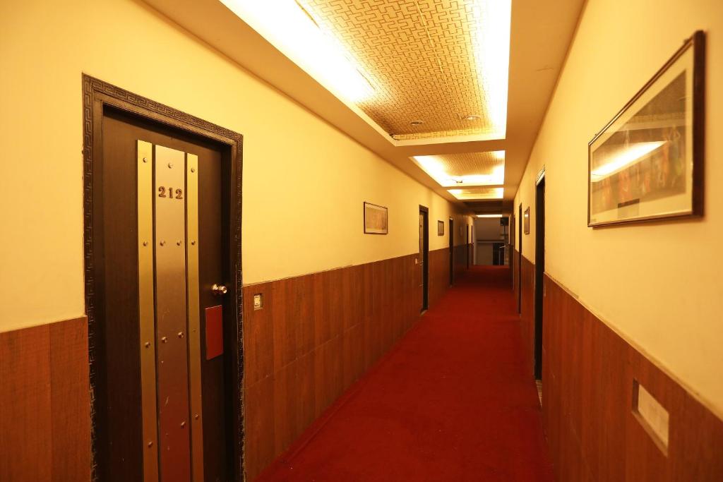 a corridor of a hallway with a long red hallway at River Bay Resort in Diamond Harbour