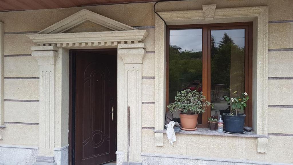 une porte d'une maison avec des plantes en pot sur une fenêtre dans l'établissement Nice House, à Ijevan