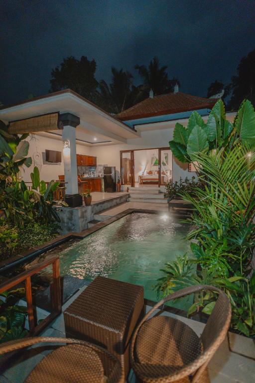 ein Schwimmbad vor einem Haus in der Nacht in der Unterkunft Tegal Harum Villa Ubud with jungle view in Ubud